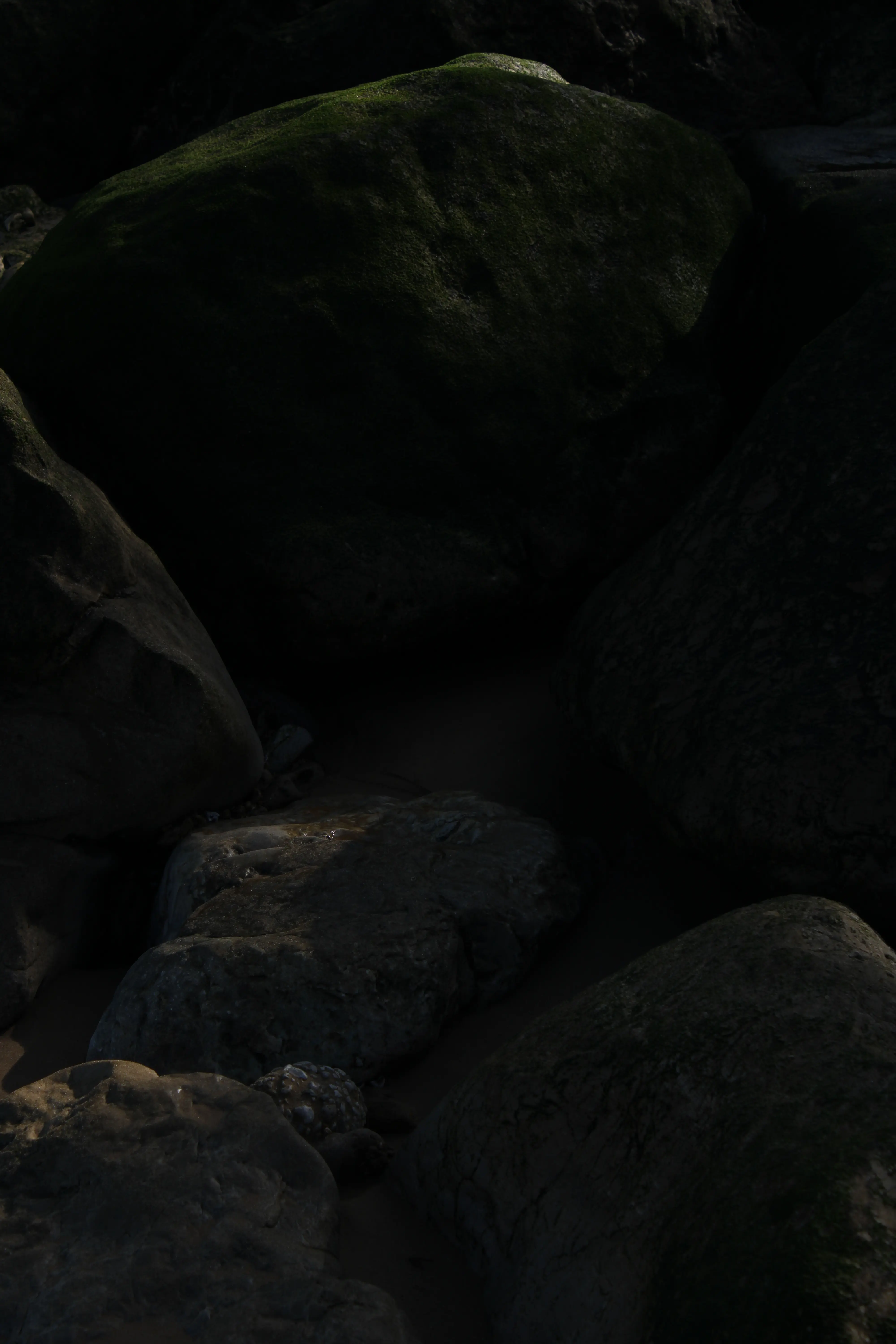 Fotografía costera tras corrección de sombras y color, mostrando la arena y las rocas con máximo detalle y viveza