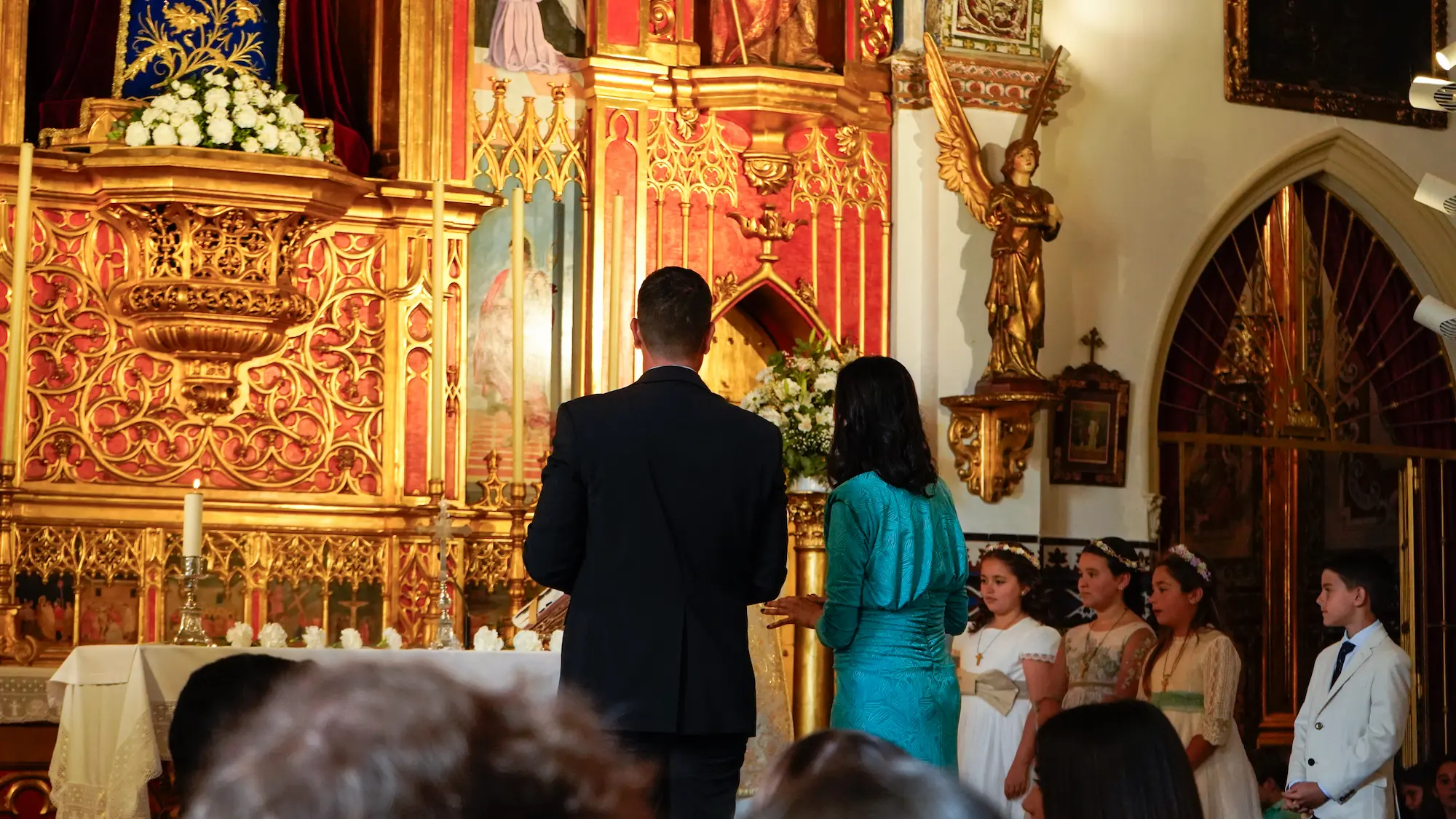 Padres emocionados mirando al altar durante una ceremonia religiosa en la iglesia