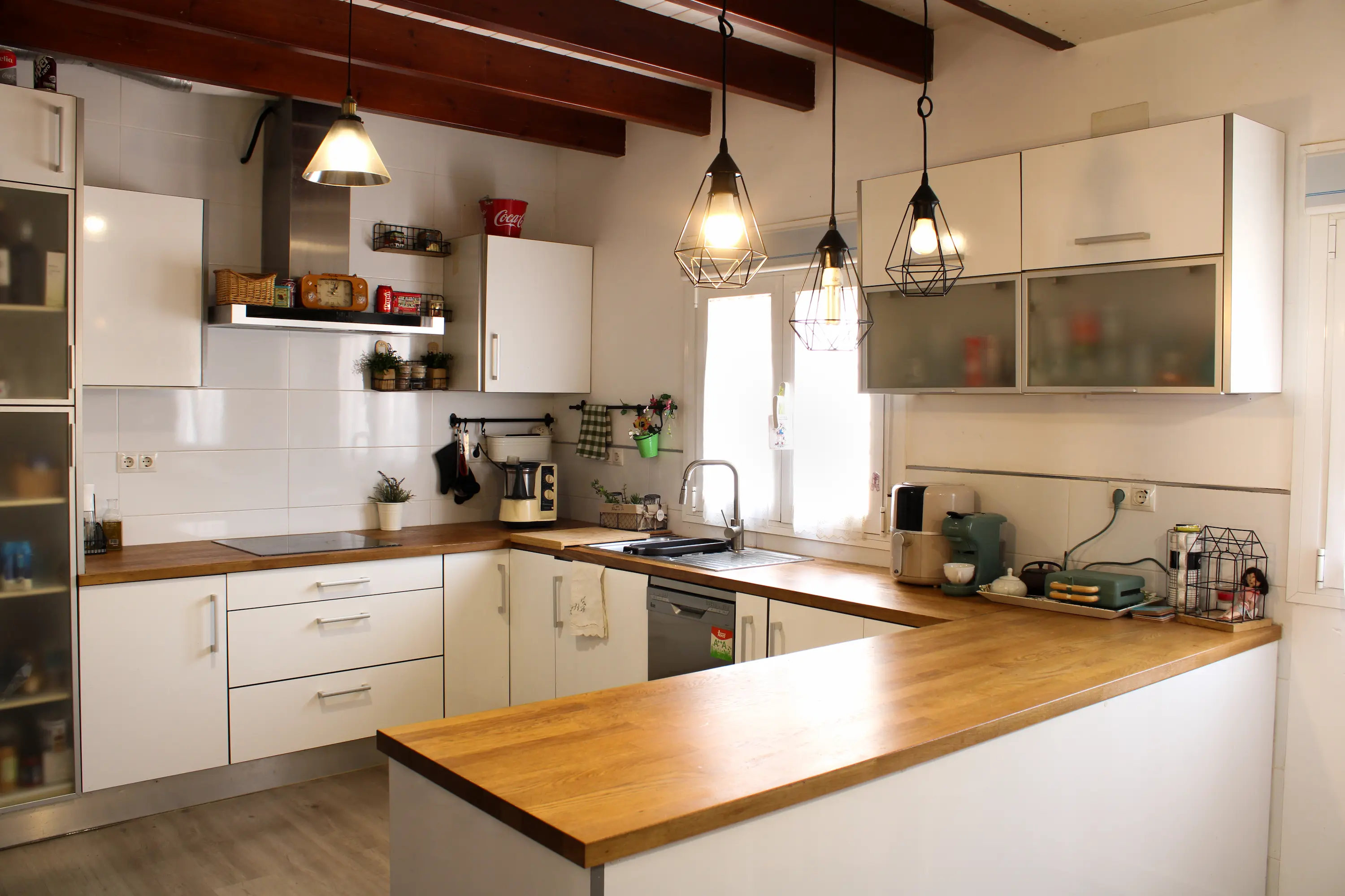 Main kitchen with white cabinetry and a window above the sink