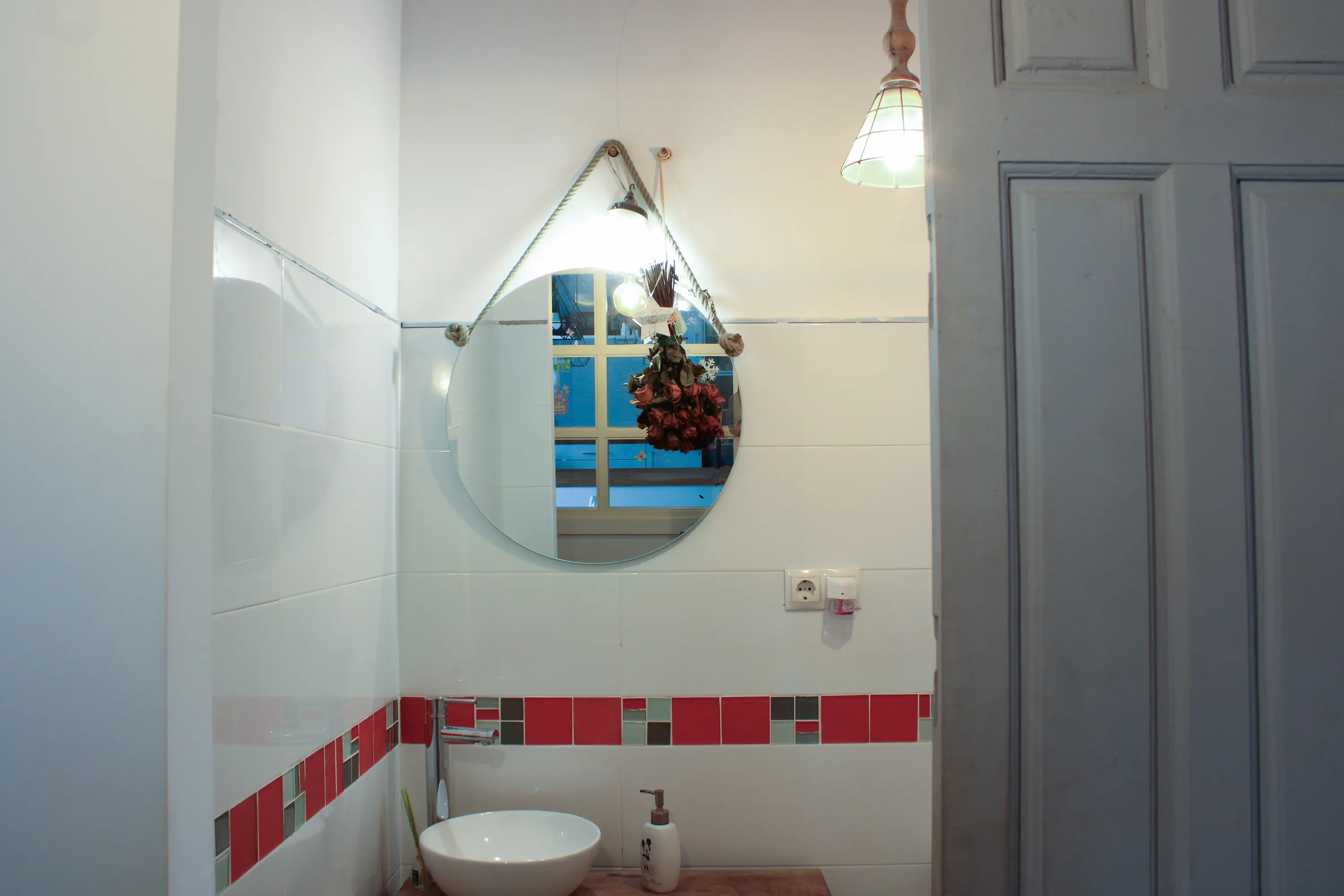 Circular wall mirror with an open door next to it