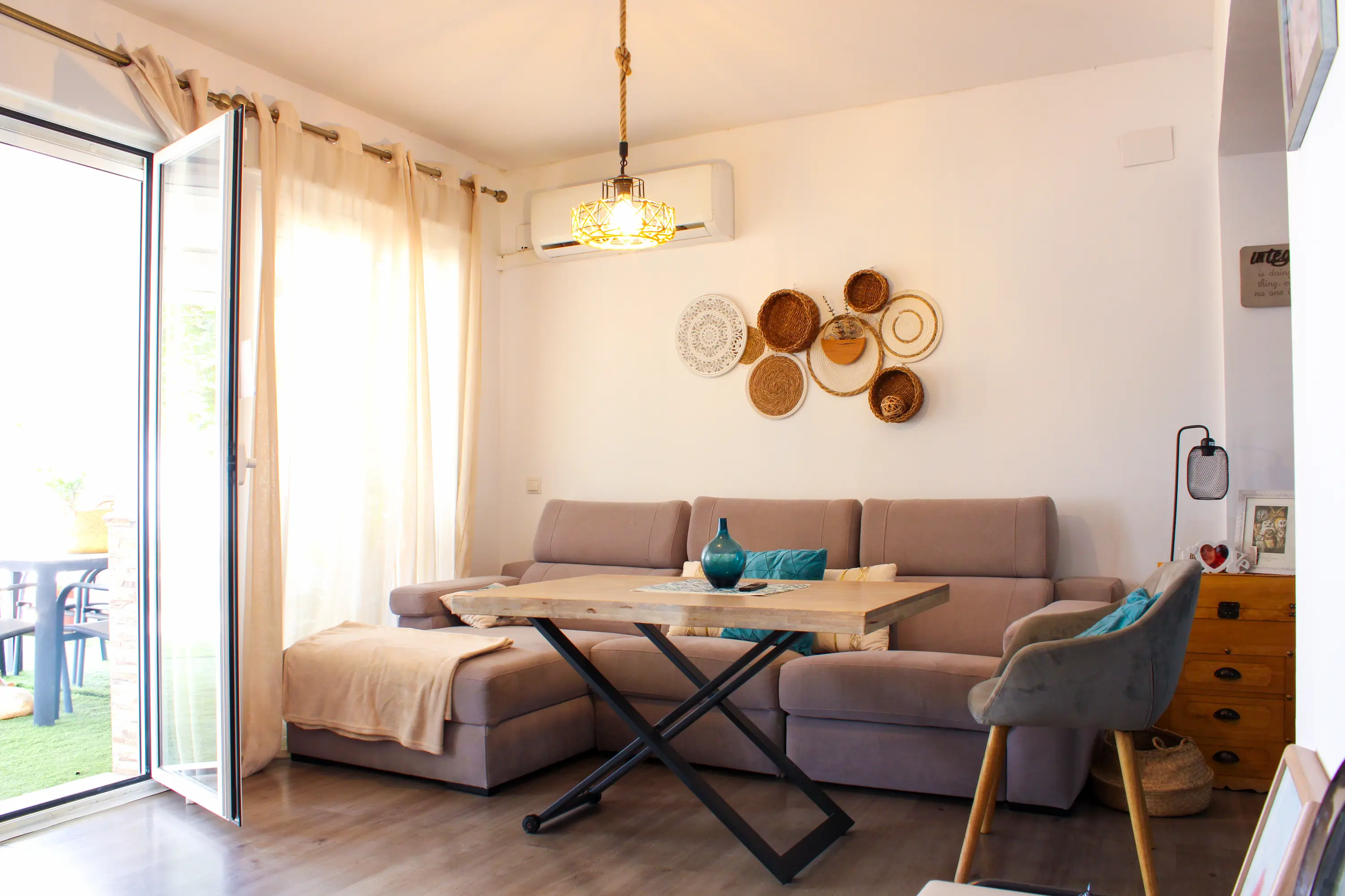 Living room seating area with a coffee table, air conditioning unit, and outdoor patio access