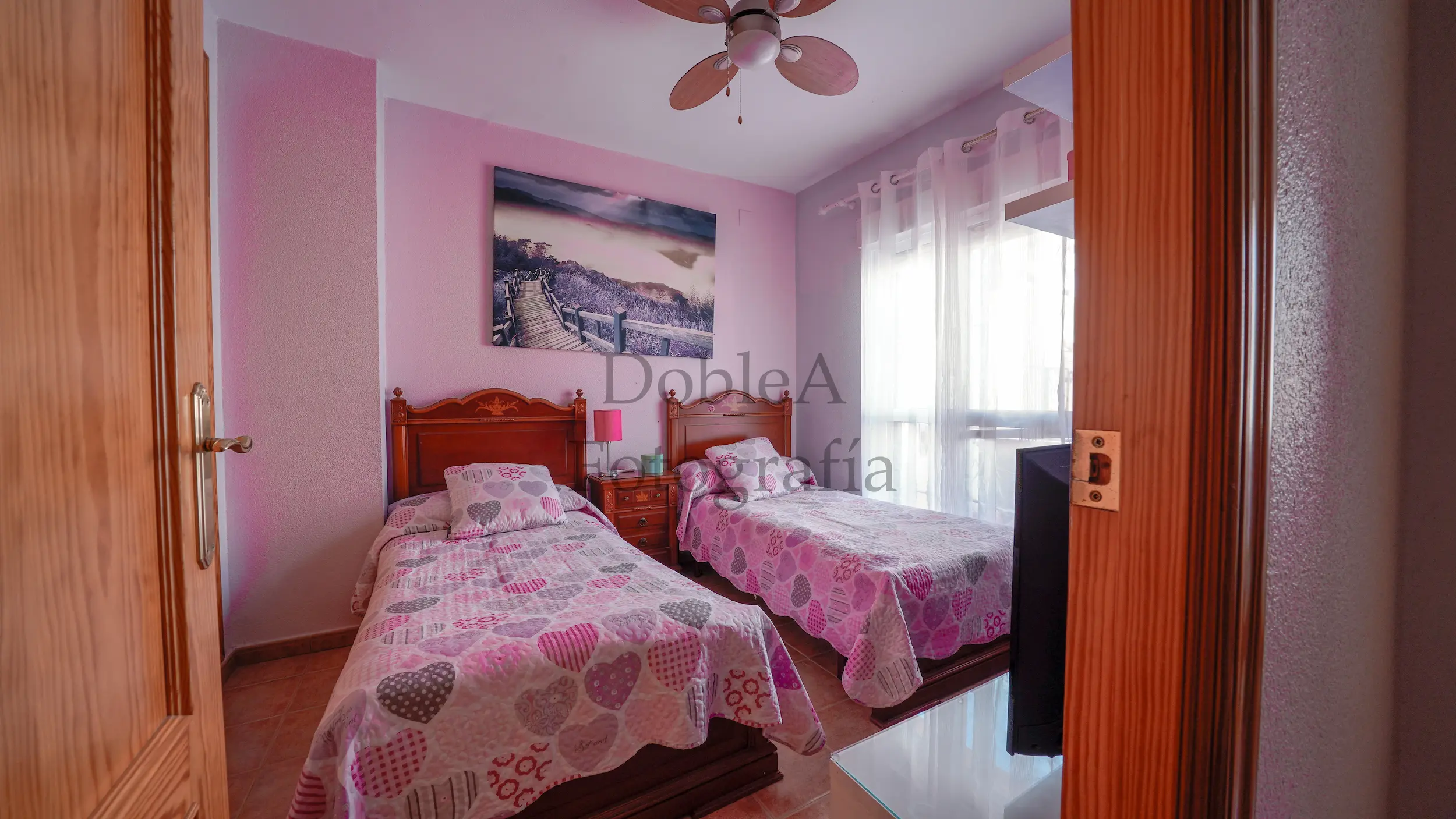 Photograph of a double room with purple walls, cozy decor, and twin beds