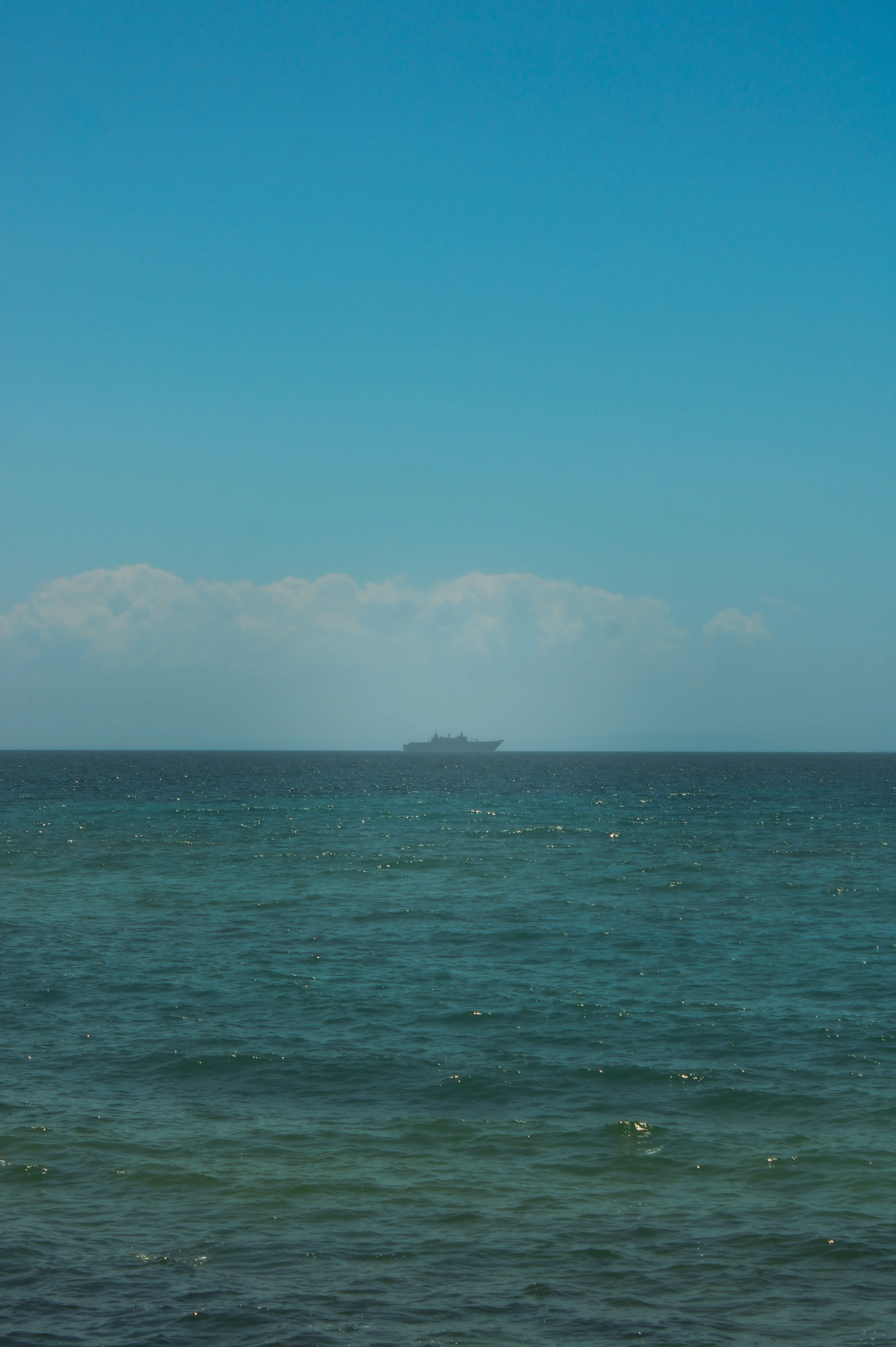Fotografía de paisaje marino con el horizonte del mar y un barco a lo lejos