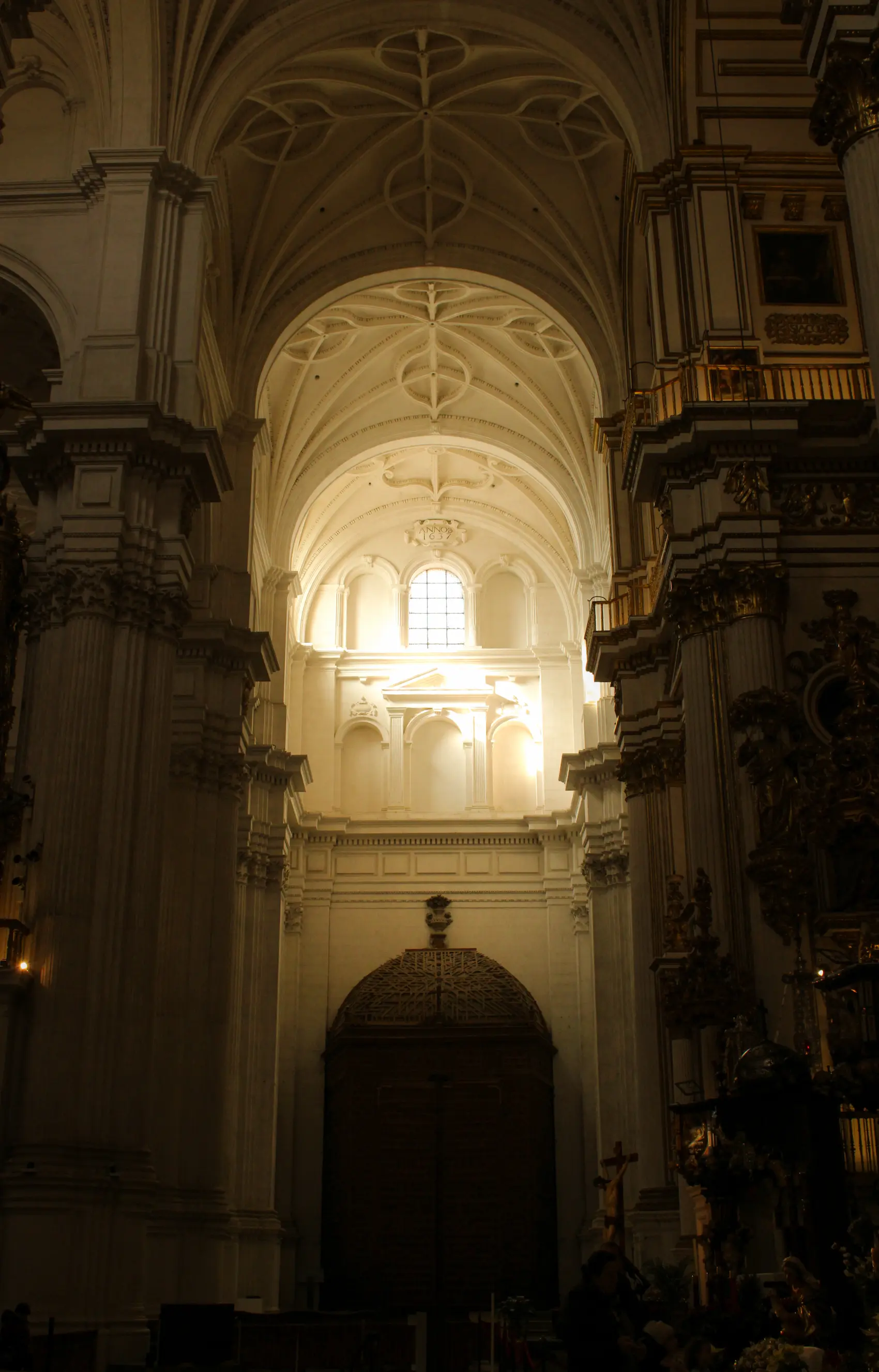 Fotografía arquitectónica del interior de una iglesia destacando los arcos abovedados y la puerta principal