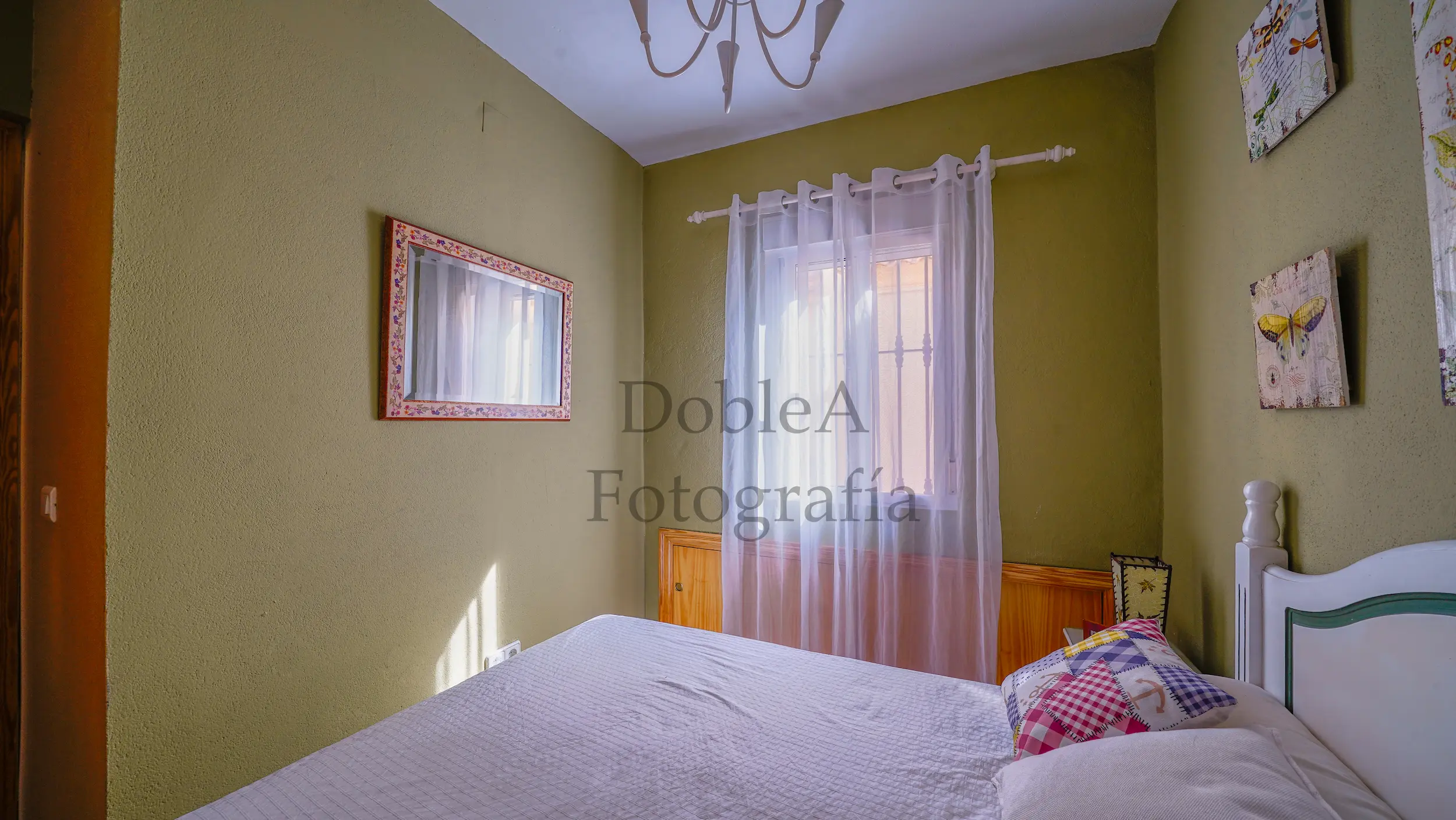 Dormitorio con paredes verdes, cama de matrimonio y excelente entrada de luz natural